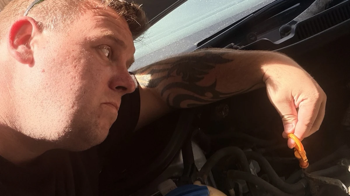 Checking engine oil as part of basic car maintenance